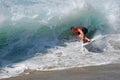 Skim Boarder riding a shore break wave at Aliso Beach in Laguna Beach, California.