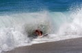 Skim Boarder riding a shore break wave at Aliso Beach in Laguna Beach, California. Royalty Free Stock Photo