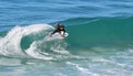 Skim Boarder riding a shore break wave at Aliso Beach in Laguna Beach, California. Royalty Free Stock Photo