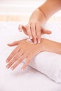 Skin, apply cream and hands in spa, closeup and massage on towel for care. Touch fingers, nails and woman on lotion Royalty Free Stock Photo