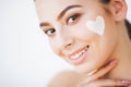 Skin Care. Beautiful model applying cosmetic cream treatment on her face Royalty Free Stock Photo