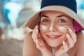 Skin care. Beauty Concept. Young pretty woman applying sun cream  and touch own face. Royalty Free Stock Photo