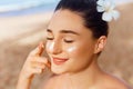 Skin care. Beauty Concept. Young pretty woman applying sun cream  and touch own face Royalty Free Stock Photo