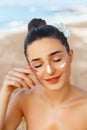 Skin care. Beauty Concept. Young pretty woman applying sun cream and touch own face. Royalty Free Stock Photo