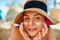 Skin care. Beauty Concept. Young pretty woman applying sun cream and touch own face. Royalty Free Stock Photo