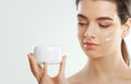 Skin care. Beauty Concept. Young pretty woman holding cosmetic cream. Soft skin and naked shoulders Royalty Free Stock Photo