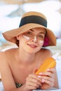 Skin care. Beauty Concept. Young pretty woman holding  sun cream and applying on her face. Royalty Free Stock Photo