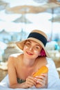 Skin care. Beauty Concept. Young pretty woman holding sun cream and applying on her face Royalty Free Stock Photo