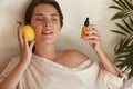 Skin Care. Beauty Portrait Of Woman Holding Lemon And Bottle Near Face. Natural Cosmetic Product For Hydrated Derma. Royalty Free Stock Photo