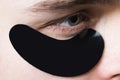 Skin care. Black pearl extract. Minimizes puffiness and reduce dark circles. Eye patches for men. Man with black eye Royalty Free Stock Photo