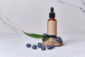 Blueberry ingredients, bottle on stone stand, Organic cosmetics