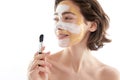 Cute smiling woman with face mask and brush