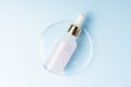 Skin care essence oil dropper glass bottle on blue background. Hydrating serum, vitamin for face skin. Aesthetic, minimalism Royalty Free Stock Photo