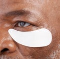 Skin care, eye mask and zoom on black man with professional anti ageing spa treatment with collagen. Dermatology
