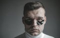 Skin care. Minimizes puffiness and reduce dark circles. Eye patches for men. Man with black eye patches close up face Royalty Free Stock Photo