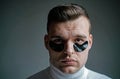 Skin care. Minimizes puffiness and reduce dark circles. Eye patches for men. Man with black eye patches close up face Royalty Free Stock Photo