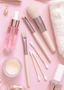 Skin care products and make up brushes on light pink, top view Royalty Free Stock Photo