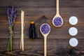 Skin care and relax. Cosmetics and aromatherapy concept. Lavender spa salt and oil on dark wooden background top view Royalty Free Stock Photo