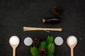 Skin care and relax. Cosmetics and aromatherapy concept. Pine spa salt, oil, spruce branch and pinecones on black