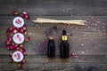 Skin care and relax. Cosmetics and aromatherapy concept. Rose oil and candles on dark wooden background top view