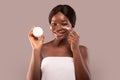 Skin Care. Smiling African Woman In Towel Applying Moisturizing Cream On Face Royalty Free Stock Photo