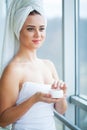 Skin care. Studio shot of beautiful young woman applying moisturizer cream onto her face Royalty Free Stock Photo