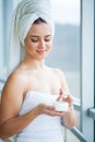 Skin care. Studio shot of beautiful young woman applying moisturizer cream onto her face Royalty Free Stock Photo