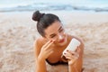 Skin care. Sun protection. Beautiful Woman In Bikini apply sun cream on Face. Beauty Woman With Suntan Lotion On Beach. Royalty Free Stock Photo