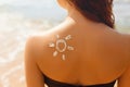 Sun cream. Suntan lotion beautiful woman applying on tanned shoulder in form of the sun. Sunscreen solar cream. Royalty Free Stock Photo