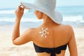 Skin care. Sun protection. Beauty Woman apply sun cream. Woman With Suntan Lotion On Beach In Form Of The Sun. Royalty Free Stock Photo