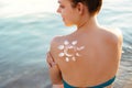 Skin care. Sun protection. Woman apply sun cream. Woman With Suntan Lotion On Beach In Form Of The Sun. Royalty Free Stock Photo