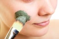 Skin care. Woman applying clay mud mask on face. Royalty Free Stock Photo