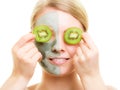 Skin care. Woman in clay mask with kiwi on face