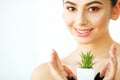 Skin Care. Woman with Clear Skin Holding Green Aloe Vera Plant. Royalty Free Stock Photo