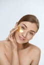 Skin care. Woman face with under eye gold patch, beauty mask Royalty Free Stock Photo