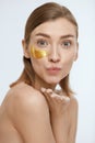 Skin care. Woman face with under eye gold patch, beauty mask Royalty Free Stock Photo