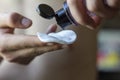 Skin care.A young man holds a cotton pad and a lotion to cleanse the skin of blackheads