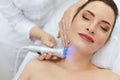 Skin Cosmetology. Woman Doing Blue Light Therapy On Neck