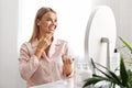 Skin Moisturising. Smiling Middle Aged Woman Applying Nourishing Cream On Face Royalty Free Stock Photo