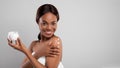 Skin Nourishing Concept. Beautiful African American Lady Applying Moisturising Body Cream Royalty Free Stock Photo
