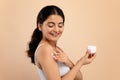 Skin Nourishing Concept. Beautiful Indian Woman Applying Moisturizing Body Cream Royalty Free Stock Photo