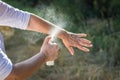 Insect repellent. Woman spraying mosquito repellent on hand. Royalty Free Stock Photo