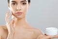 Skincare.Beautiful Young Woman with Clean Fresh Skin Holding Bottle. Beauty face care. Facial treatment. Cosmetology.