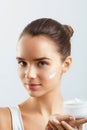 Skincare. Beauty Concept. Young Pretty Woman Holding Cosmetic Cream.Girl wiht fresh skin Royalty Free Stock Photo