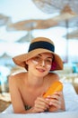 Skincare. Beauty Concept. Young pretty woman holding sun cream and applying on her face. Royalty Free Stock Photo