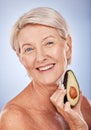 Skincare, beauty and senior woman with avocado for health, wellness and diet against a grey studio background. Fruit Royalty Free Stock Photo