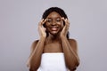 Daily Skincare. Cheerful Attractive Black Woman Wrapped In Towel Touching Her Skin Royalty Free Stock Photo