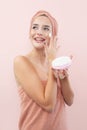 Skincare, cheerful young woman laughing, applying moisturizing cream on face, lotion or mask for skin lifting and anti-aging, Royalty Free Stock Photo