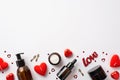 Skincare concept. Top view photo of amber cosmetic bottles red heart shaped candles candies inscription love small keys and