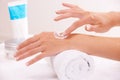 Skincare, cream and hands closeup in spa, touch and massage on towel. Fingers, nails and woman apply lotion in treatment Royalty Free Stock Photo